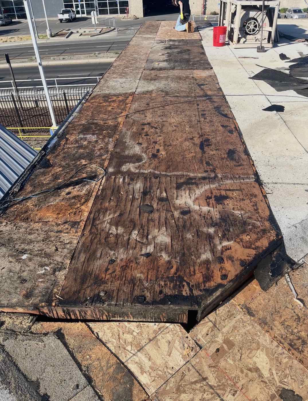 Commercial roof tear-off exposing old decking, Merced, CA